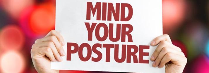 person holding card saying mind your posture