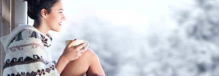 woman with mug looking out window